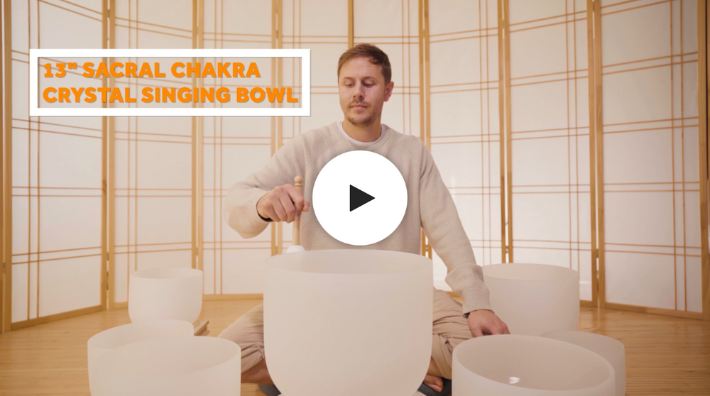 man playing sacral chakra crystal singing bowl